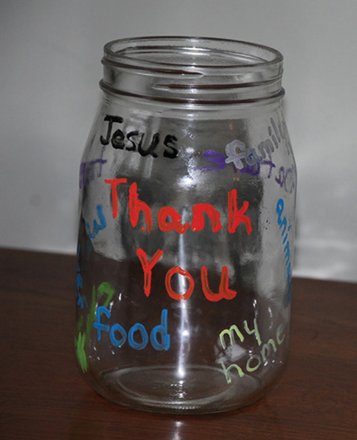 A glass jar painted with Thank You, Jesus, family, food, and my home